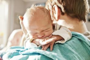 Vater hält seinen neugeborenen Sohn nach der Geburt im Arm.